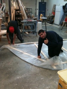 Alex Moore and Richard Munoz stapling the visqueen to the end of the hoop house.